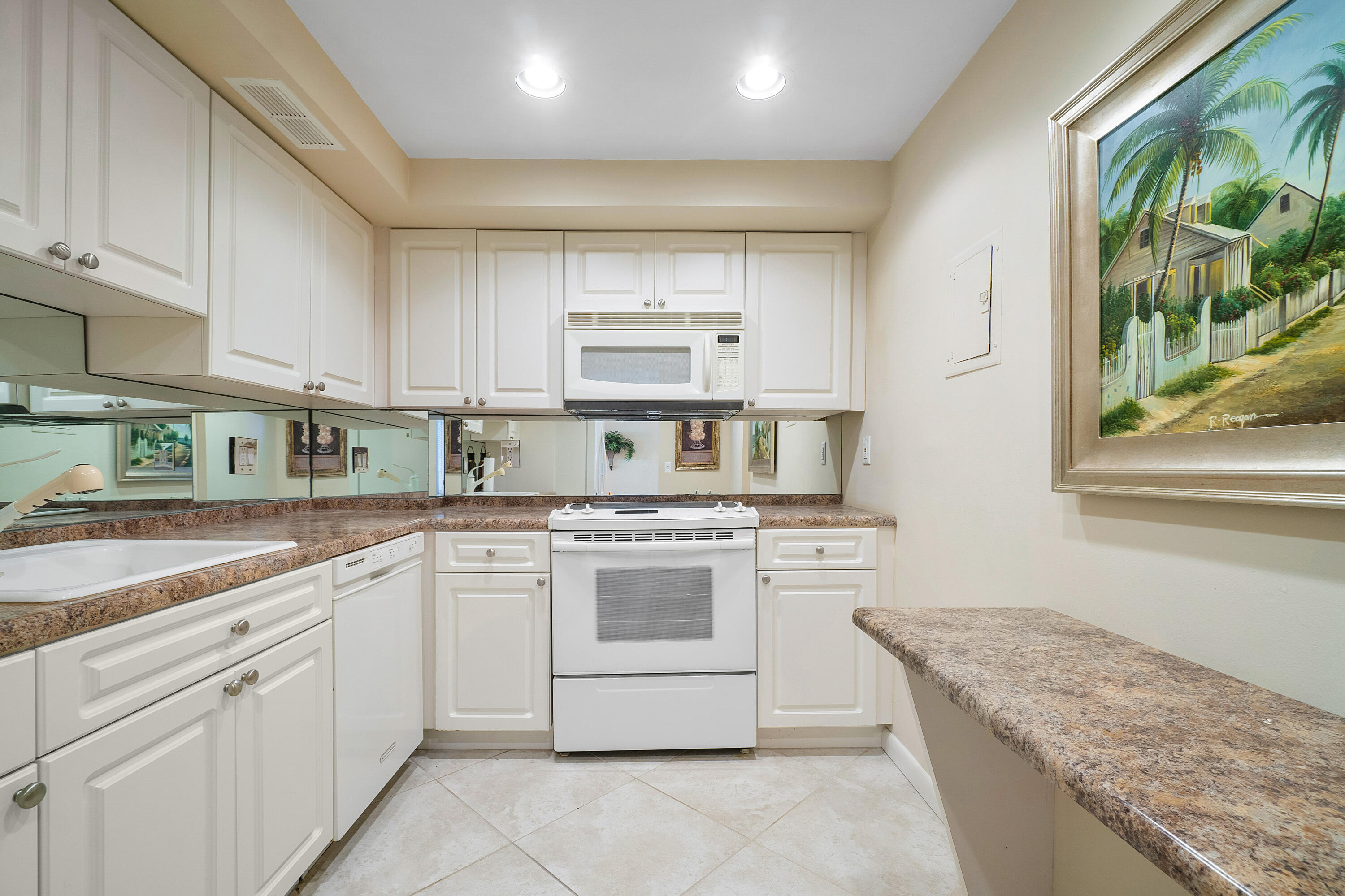 3450 South Ocean Boulevard, Unit 625 Palm Beach, FL 33480 - Photo 7 of 43 a kitchen with a stove top oven sink and cabinets