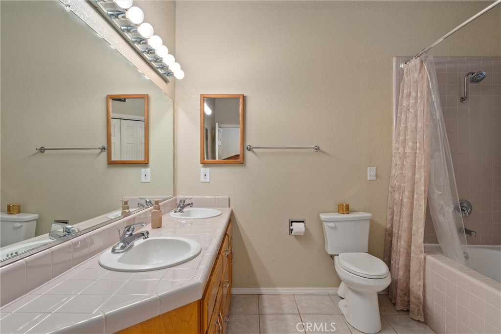 3385 Keefer Road Chico, CA 95973 - Photo 19 of 40 a bathroom with a granite countertop toilet a sink and a mirror