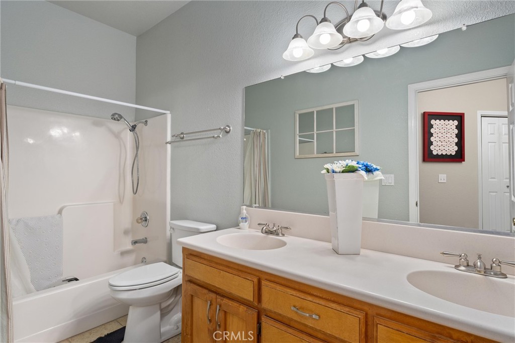 3385 Keefer Road Chico, CA 95973 - Photo 24 of 40 a bathroom with a granite countertop sink a toilet and a mirror