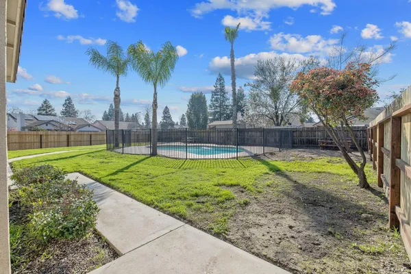 a view of a house with backyard and trees
