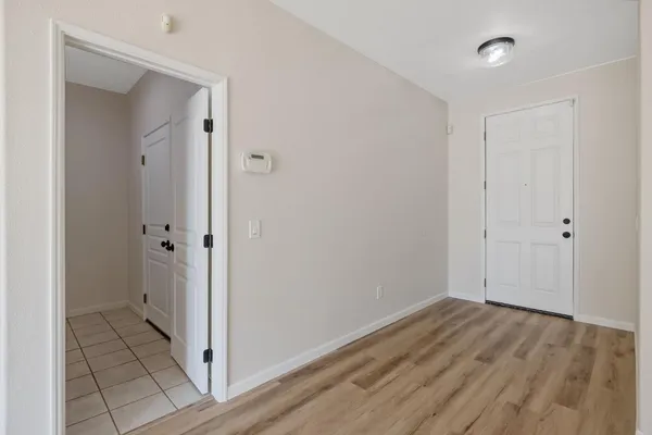 a kitchen with white cabinets and wooden floor