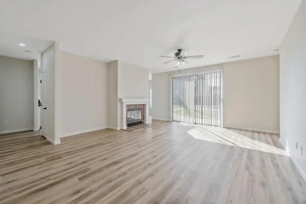 an empty room with a window and a fan