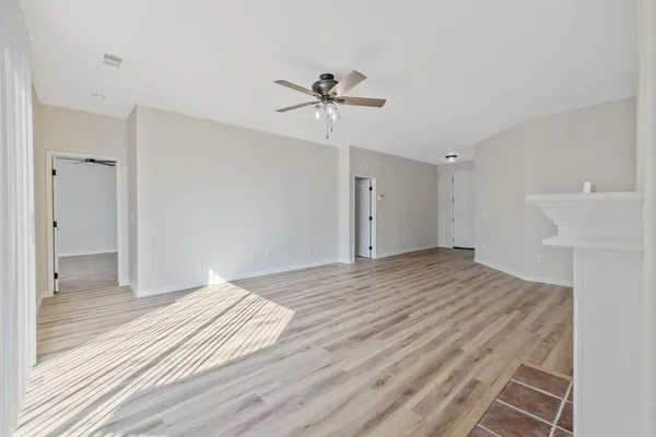 a view of a room with wooden floor and a bathroom