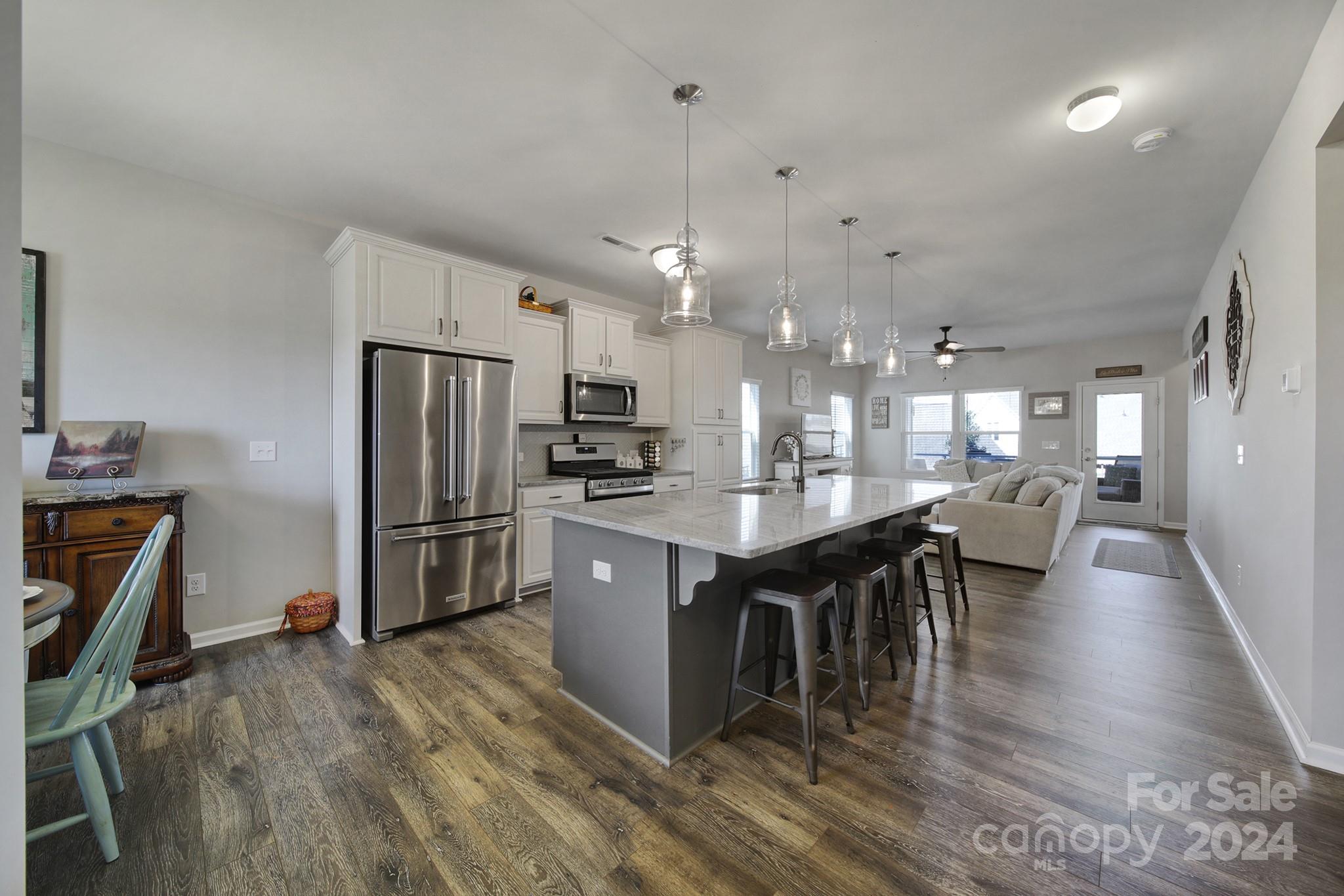 27443 Cinderella Circle Lancaster, SC 29720 - Photo 2 of 37 a kitchen with stainless steel appliances kitchen island granite countertop a refrigerator a stove a sink a dining table and chairs with wooden floor
