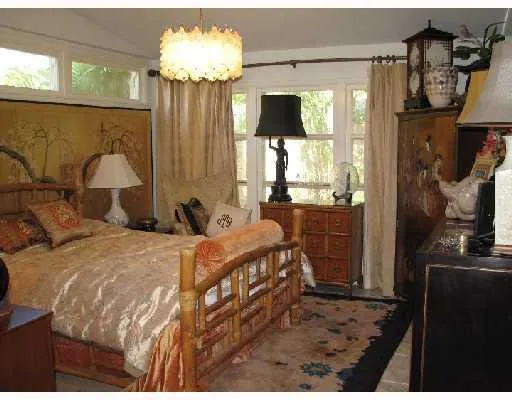 a bedroom with a bed mirror and window