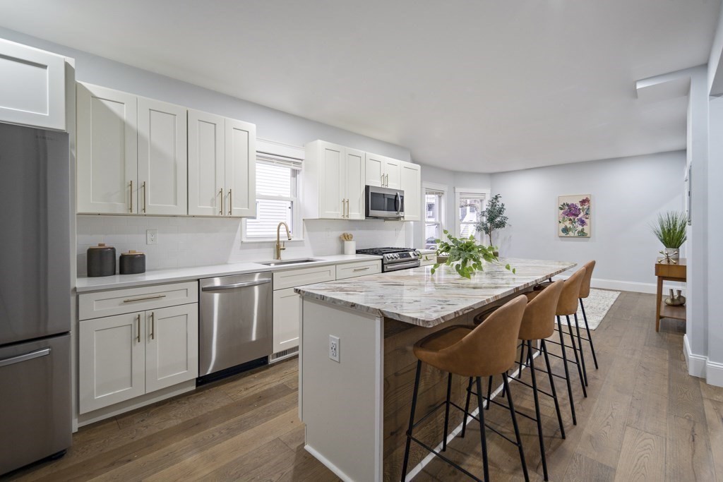 75 Tower Street, Unit 2 Boston, MA 02130 - Photo 2 of 15 a kitchen with granite countertop white cabinets and stainless steel appliances