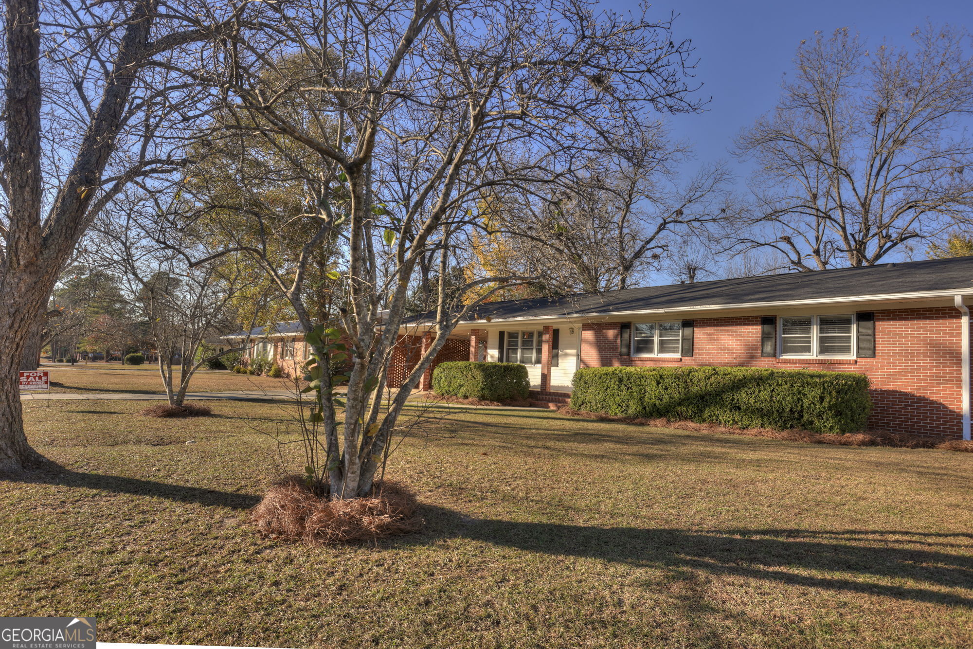 a front view of a house with a yard and potted plants