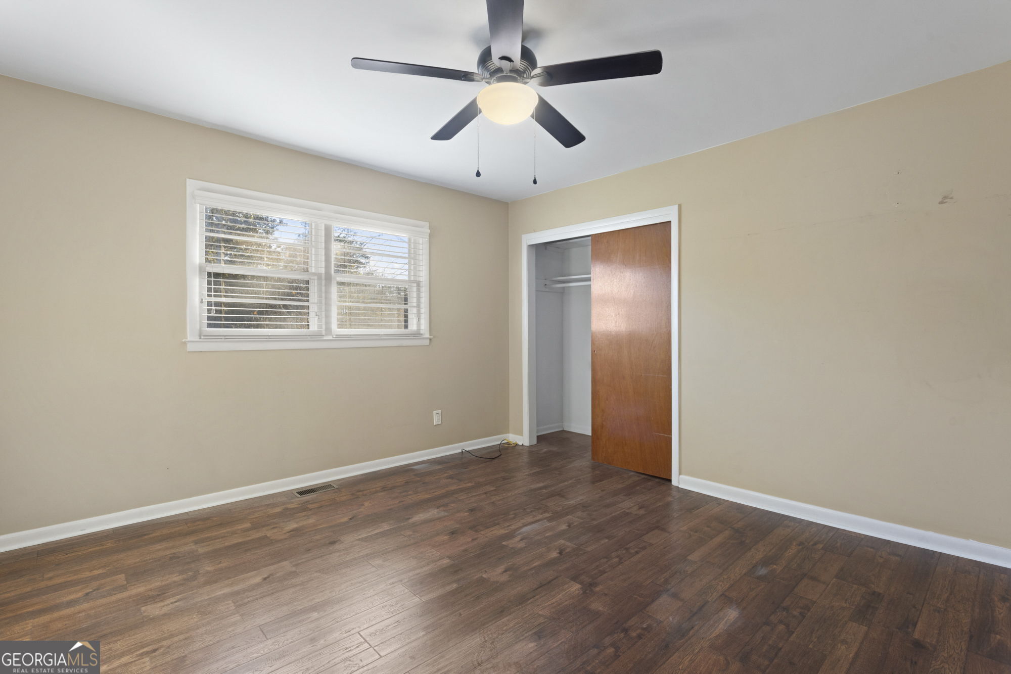 1423 Tucker Road Perry, GA 31069 - Photo 18 of 37 a view of an empty room with wooden floor and a ceiling fan