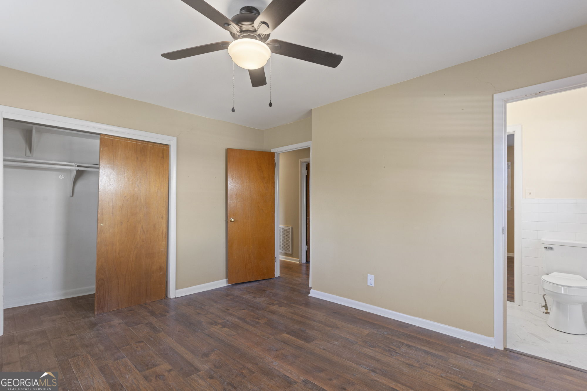 1423 Tucker Road Perry, GA 31069 - Photo 23 of 37 an empty room with wooden floor and a ceiling fan