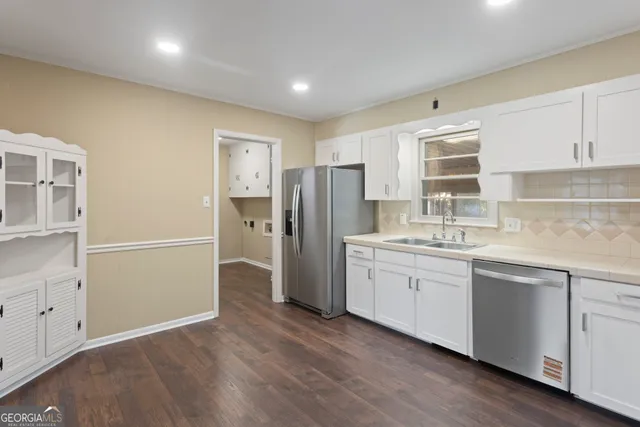 a kitchen with a refrigerator sink and cabinets