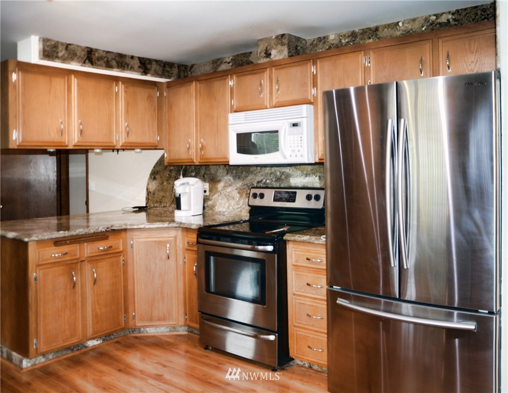 1024 South Machias Road Snohomish, WA 98290 - Photo 5 of 36 a kitchen with stainless steel appliances granite countertop a refrigerator stove and sink