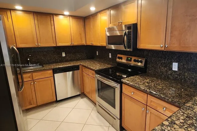 a kitchen with stainless steel appliances granite countertop a sink stove and microwave