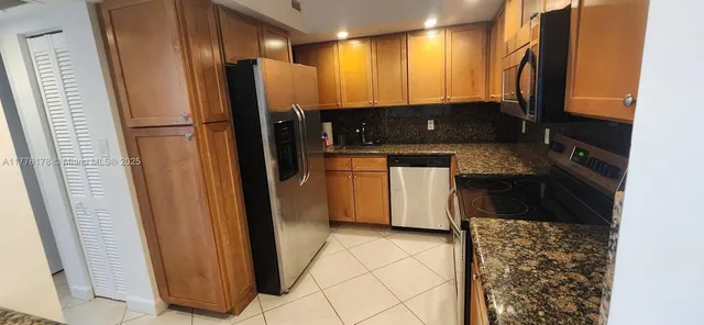 a kitchen with stainless steel appliances granite countertop a refrigerator and a sink