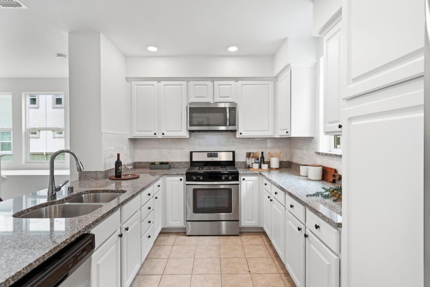 1419 Lavender Loop Milpitas, CA 95035 - Photo 10 of 38 a kitchen with stainless steel appliances granite countertop a sink stove and cabinets