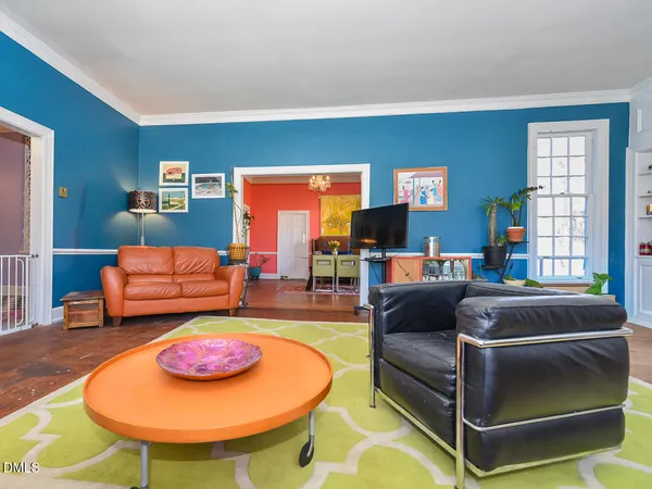 a living room with furniture a chandelier and a fireplace