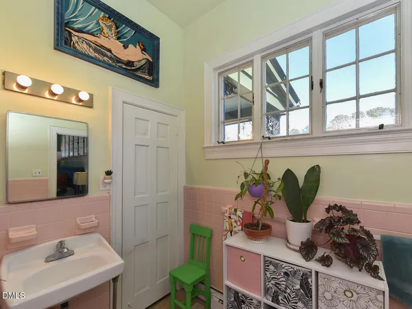 a view of a hallway to a livingroom with wooden floor and windows