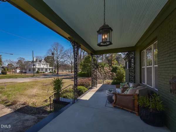 a view of a swimming pool with couches chairs and potted plants