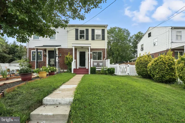 a front view of a house with a yard and potted plants