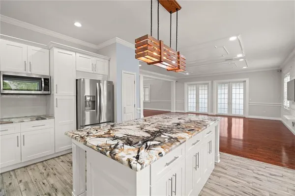 a kitchen with kitchen island granite countertop a stove and a refrigerator