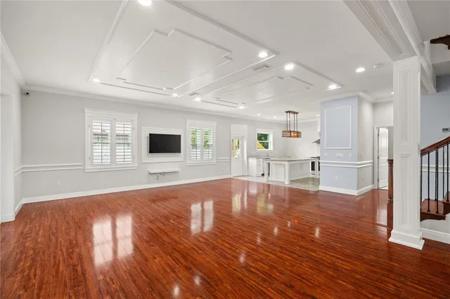 a view of empty room with wooden floor and windows