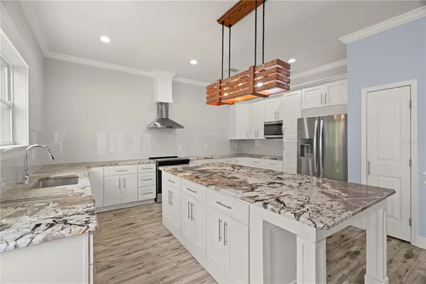 a kitchen with stainless steel appliances granite countertop a sink stove and refrigerator