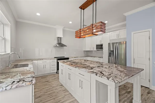 a kitchen with stainless steel appliances granite countertop a sink stove and refrigerator