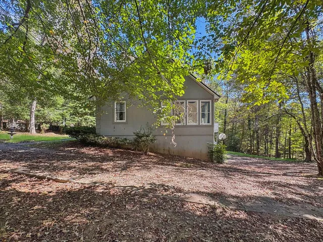 a view of a livingroom with furniture chandelier and a large window