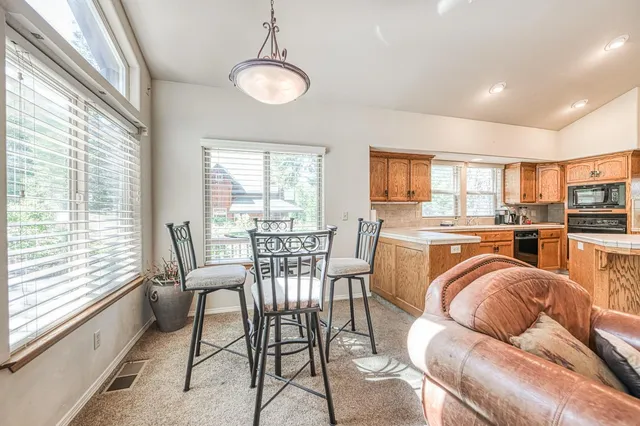 a large kitchen with stainless steel appliances granite countertop a stove a sink and a microwave