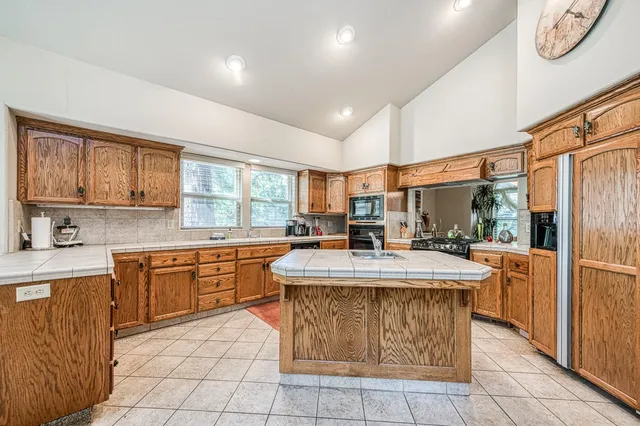 a kitchen with stainless steel appliances granite countertop a stove a sink and a refrigerator