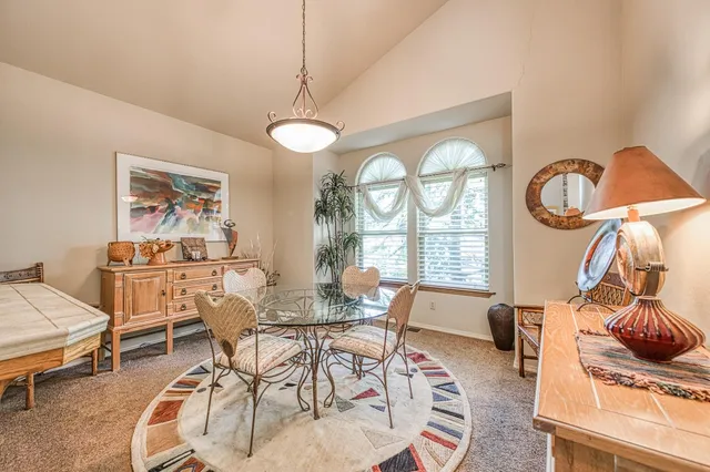 a living room with couches a table and chairs with a dining table