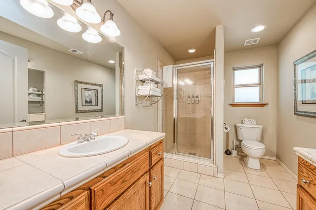a bedroom with a bed and a flat tv screen on the dresser
