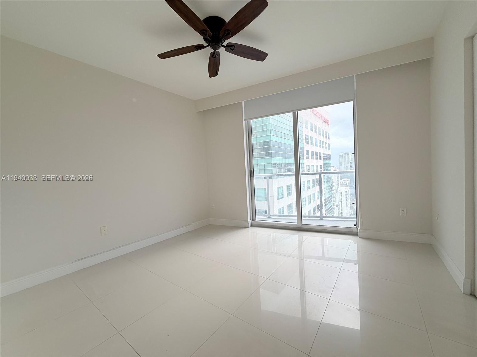 185 Southwest 7th Street, Unit 2404 Miami, FL 33130 - Photo 11 of 20 an empty room with windows and ceiling fan