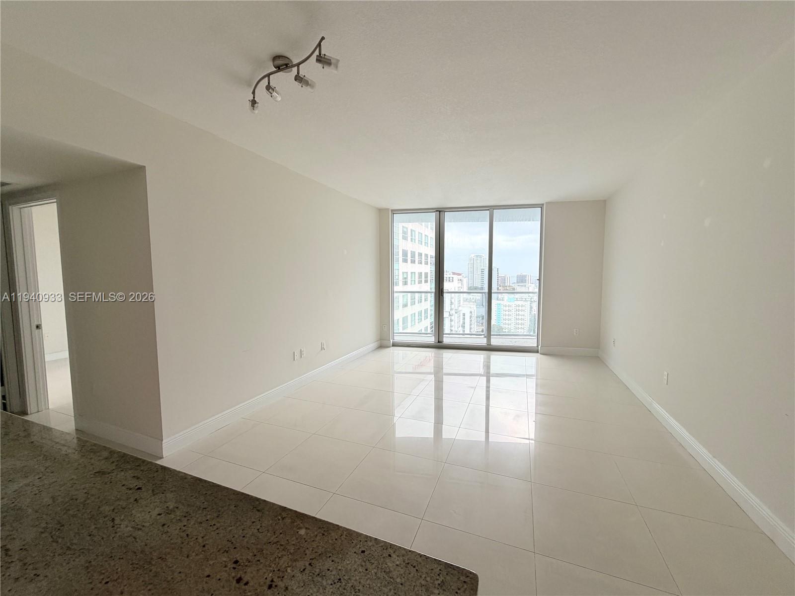 185 Southwest 7th Street, Unit 2404 Miami, FL 33130 - Photo 5 of 20 an empty room with windows and ceiling fan