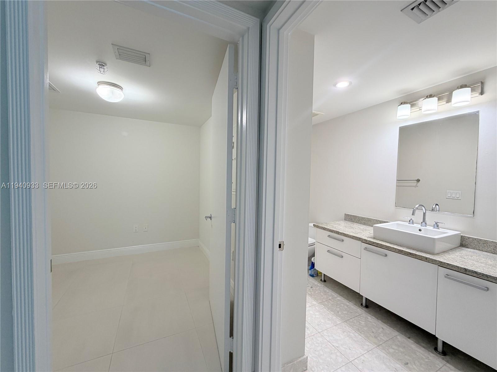 185 Southwest 7th Street, Unit 2404 Miami, FL 33130 - Photo 9 of 20 a bathroom with a double vanity sink and a mirror