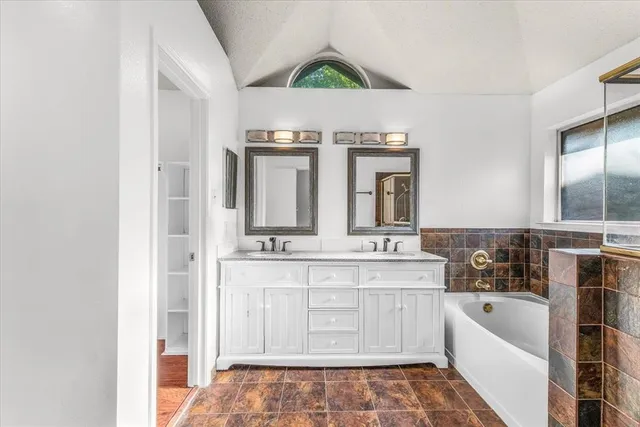 a bathroom with a tub sink and mirror