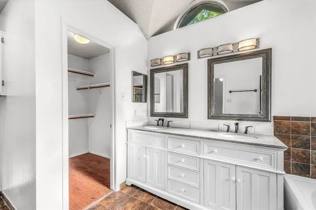 a bathroom with a double vanity sink and mirror
