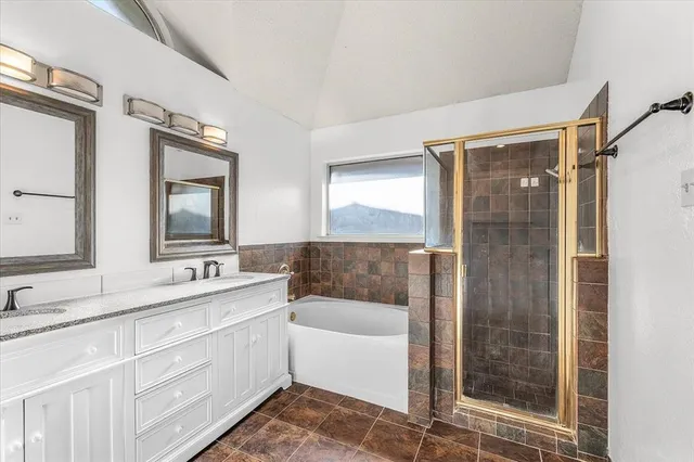 a bathroom with a double vanity sink mirror and shower