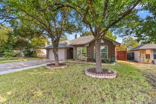 a front view of a house with a yard garden and fountain