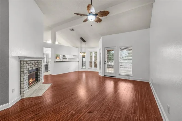 a view of empty room with wooden floor and fireplace