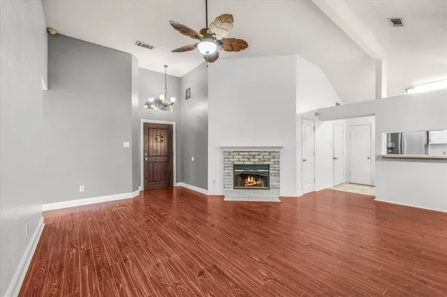 a view of empty room with wooden floor and fireplace