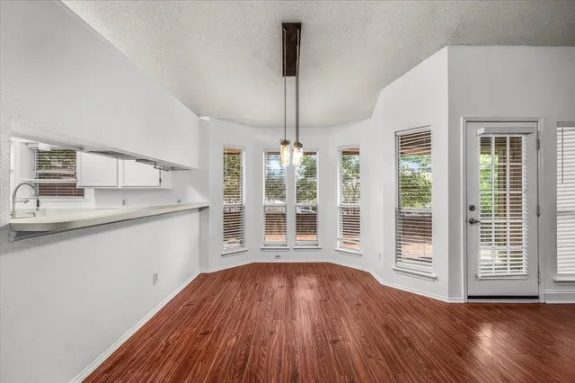 a view of a kitchen with wooden floor and a sink