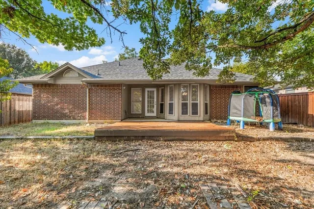 a view of a house with a yard and large tree