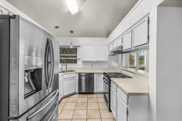 a kitchen with stainless steel appliances granite countertop a stove and a refrigerator