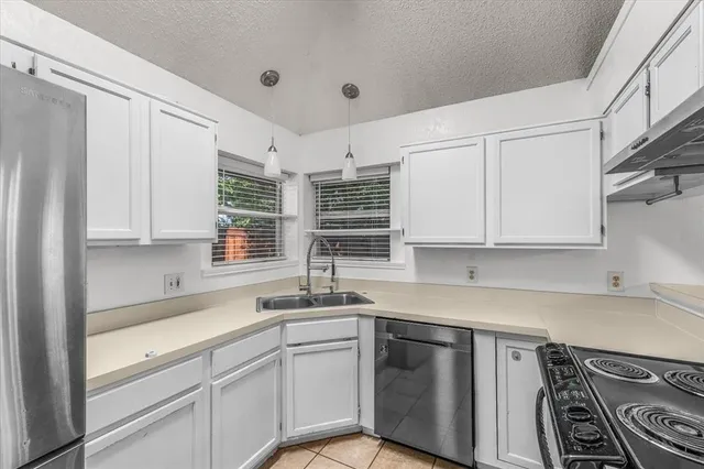 a kitchen with stainless steel appliances granite countertop a sink stove and cabinets