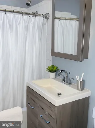 a bathroom with a sink a mirror and a shower curtain