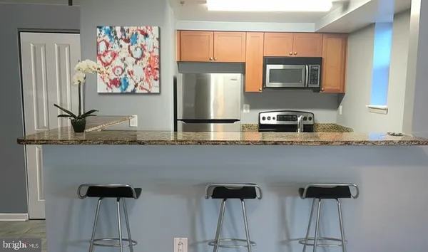 a kitchen with stainless steel appliances granite countertop a refrigerator and a stove top oven
