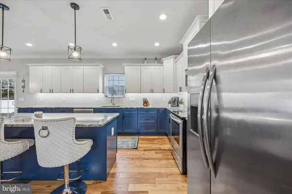 a kitchen with kitchen island a counter top space appliances and cabinets