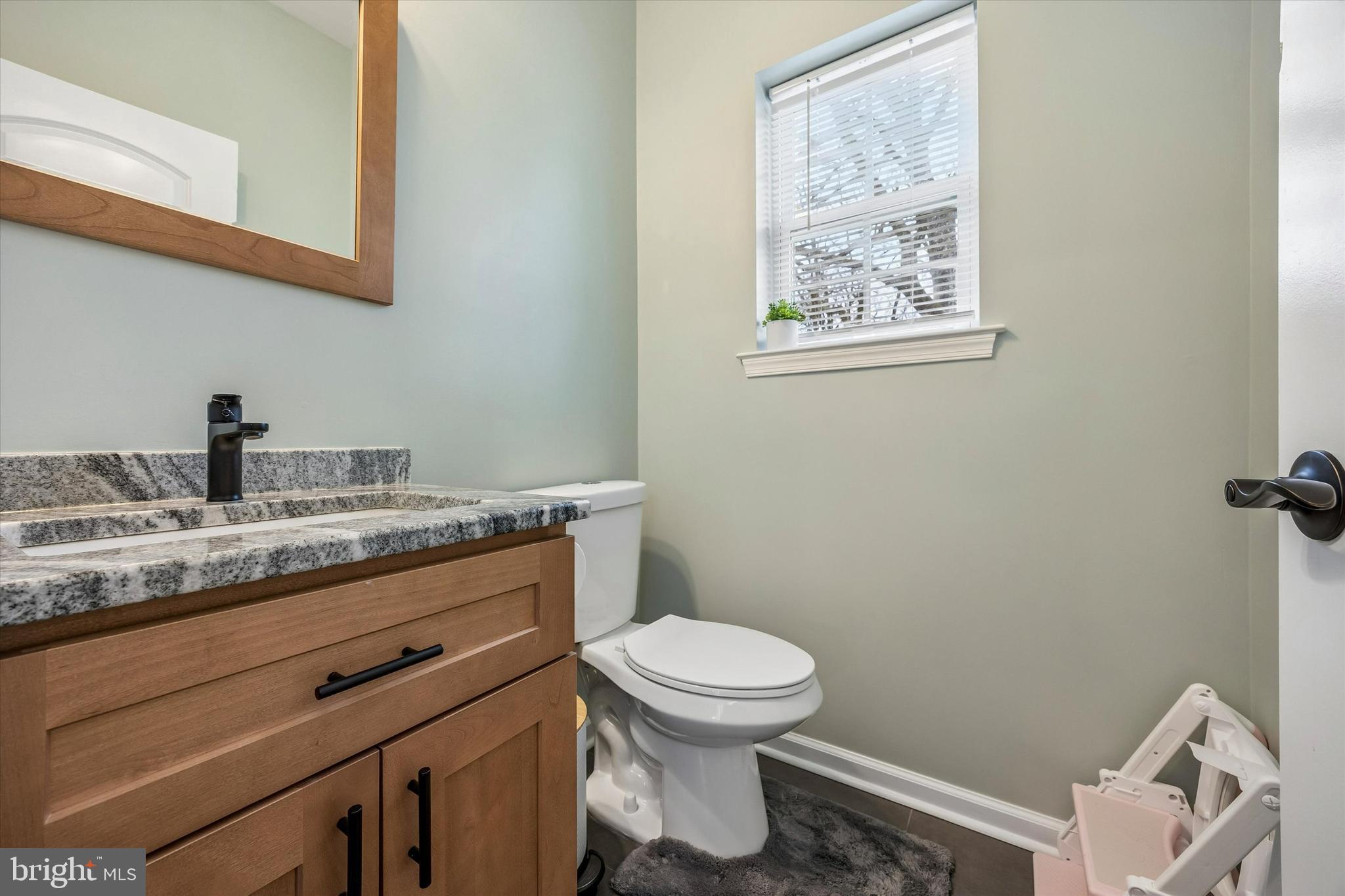 709 Shadyside Avenue Croydon, PA 19021 - Photo 17 of 40 a bathroom with a granite countertop toilet a sink and mirror