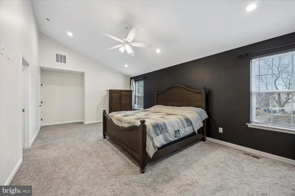 a spacious bedroom with a bed and a window