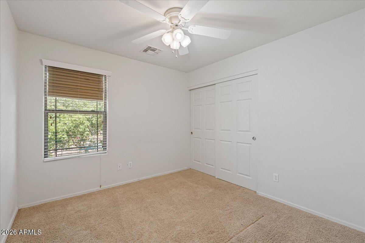 1255 South Rialto, Unit 106 Mesa, AZ 85209 - Photo 18 of 32 an empty room with a chandelier fan and windows